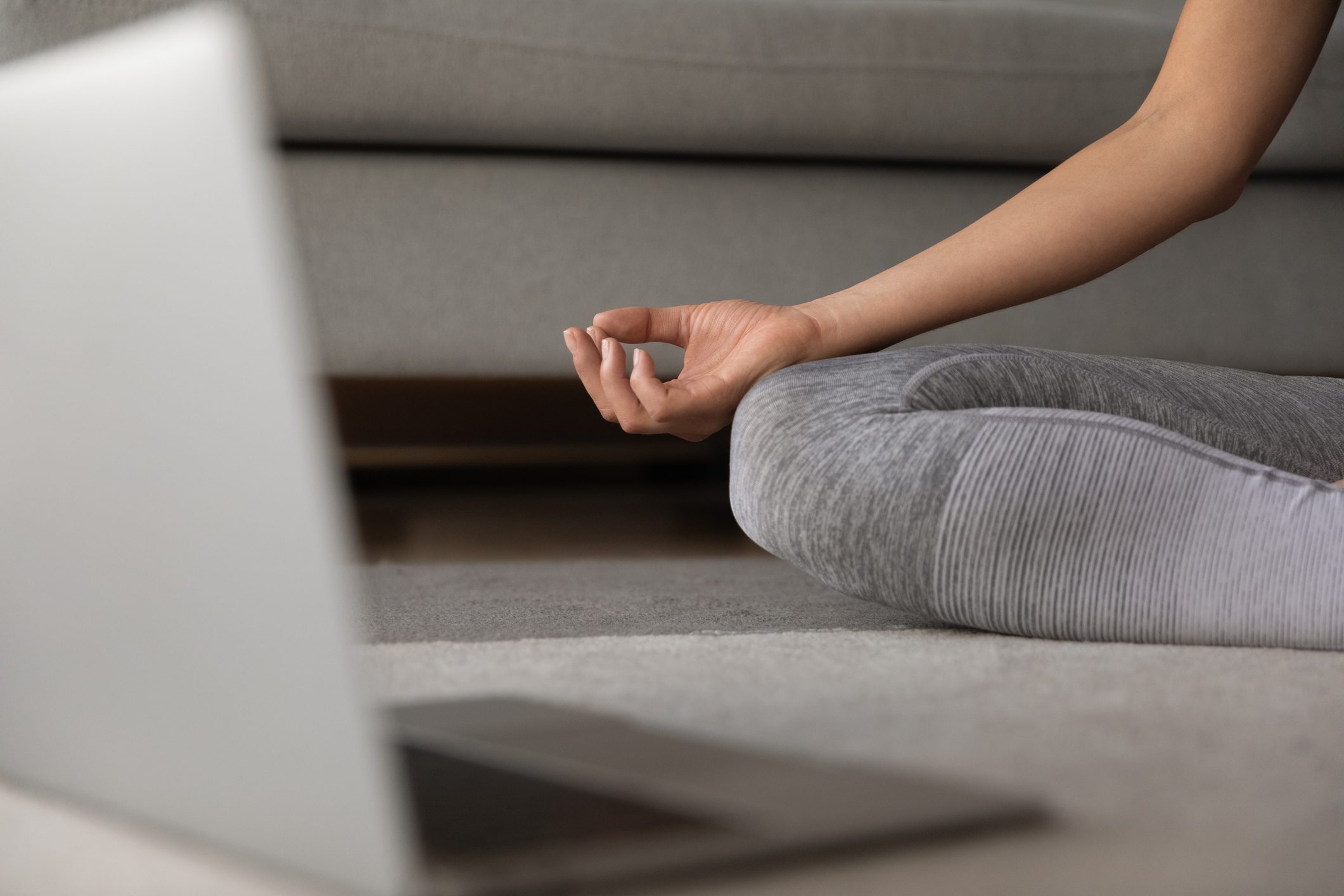 A Person Sitting on the Floor in Front of a Laptop, Meditating