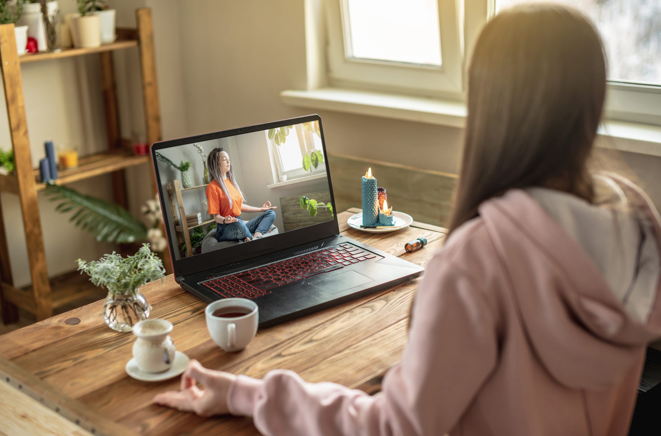 A Woman Is Sitting at a Desk With a Laptop Open